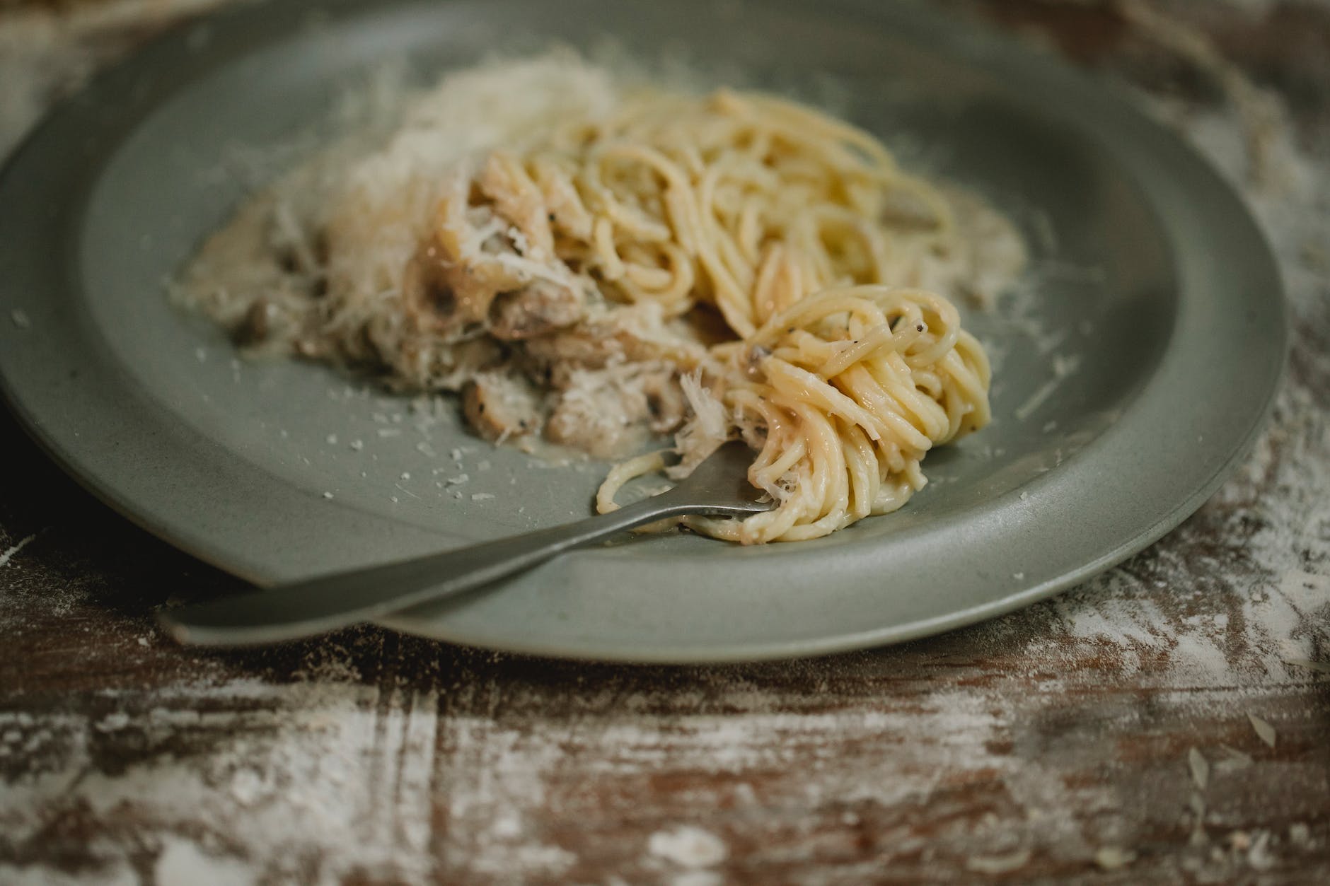 fork placed on delicious spaghetti with cream sauce
