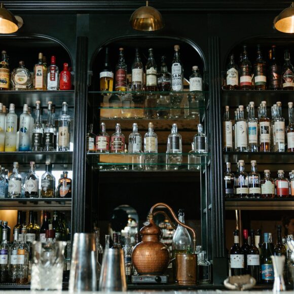 clear glass bottles on brown wooden shelf