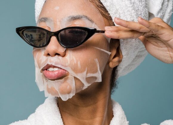content young black woman wearing sunglasses during skin care treatment after bath