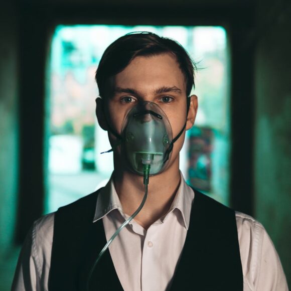 man in shirt with vest and in oxygen mask