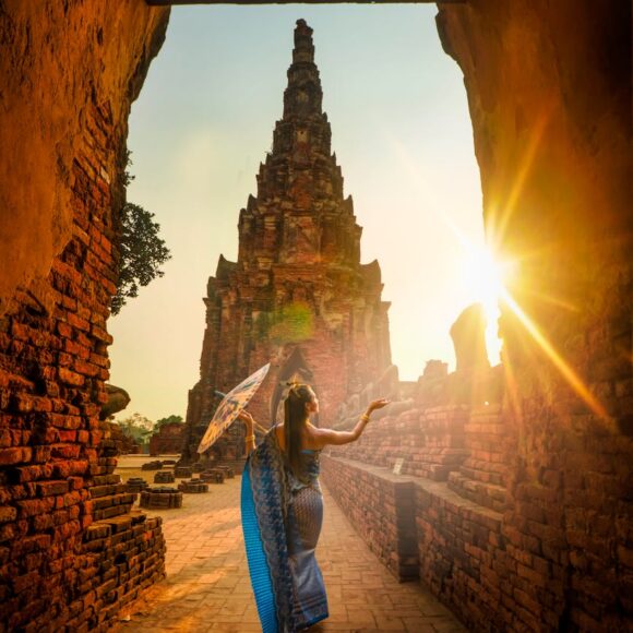 woman wearing blue dress with umbrella during sunset